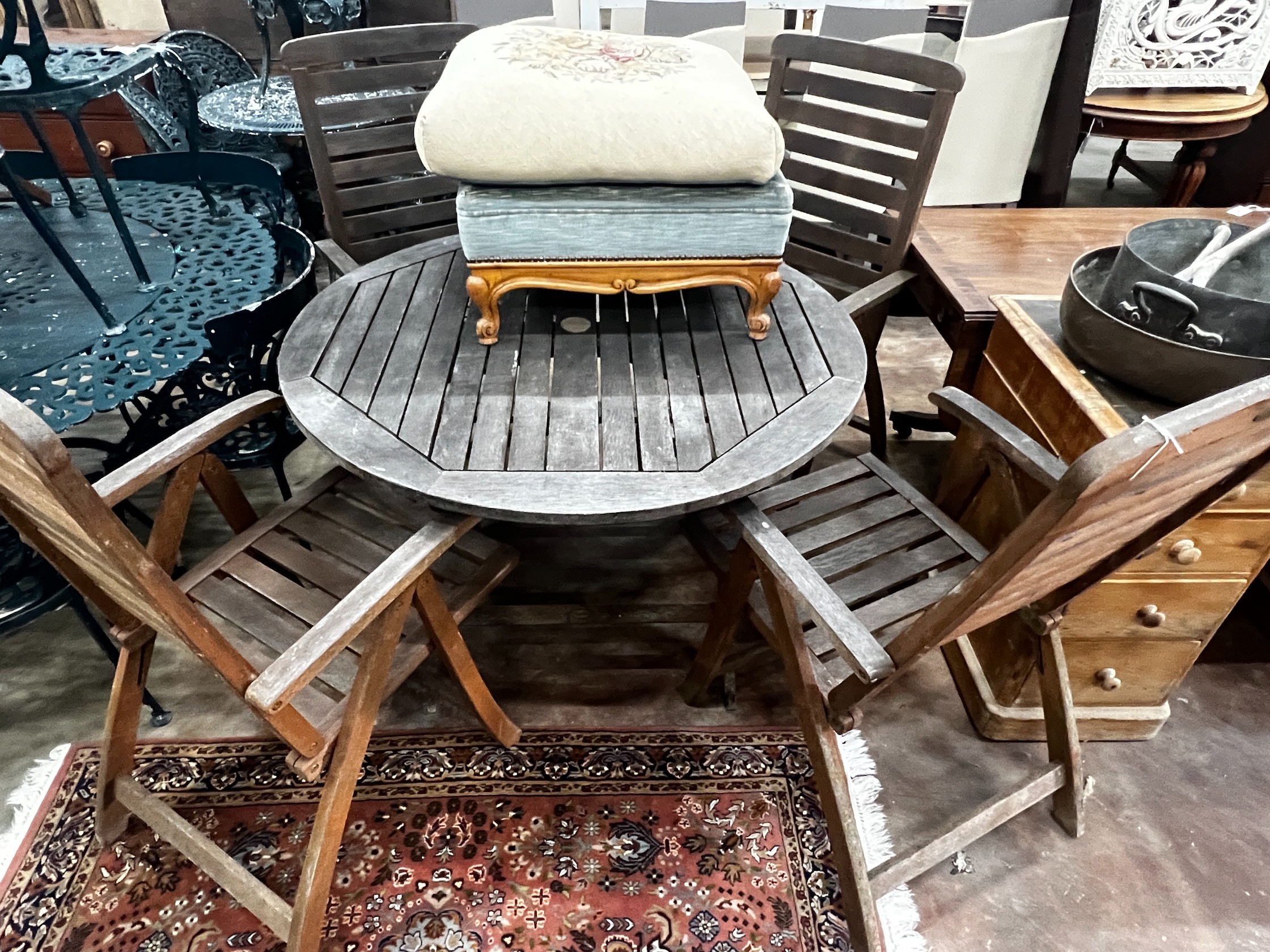 A circular weathered teak folding garden table and four teak folding armchairs, stamped Royal Craft, table 110cm diameter height 74cm
